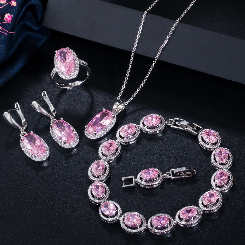 Silver-tone jewelry set with oval pink CZ ring, earrings, bracelet, and necklace