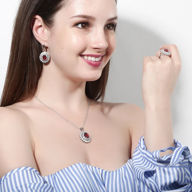 Red oval cubic zirconia jewelry modeled as a flower-halo necklace, earring, and ring