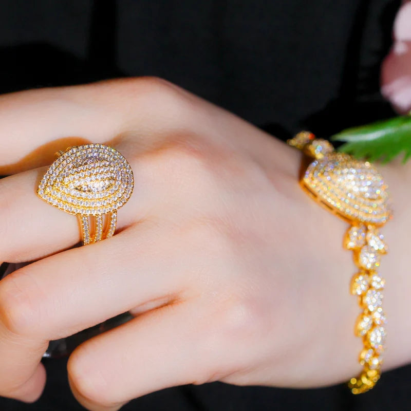 Gold-tone teardrop zircon ring and matching bracelet worn on a hand