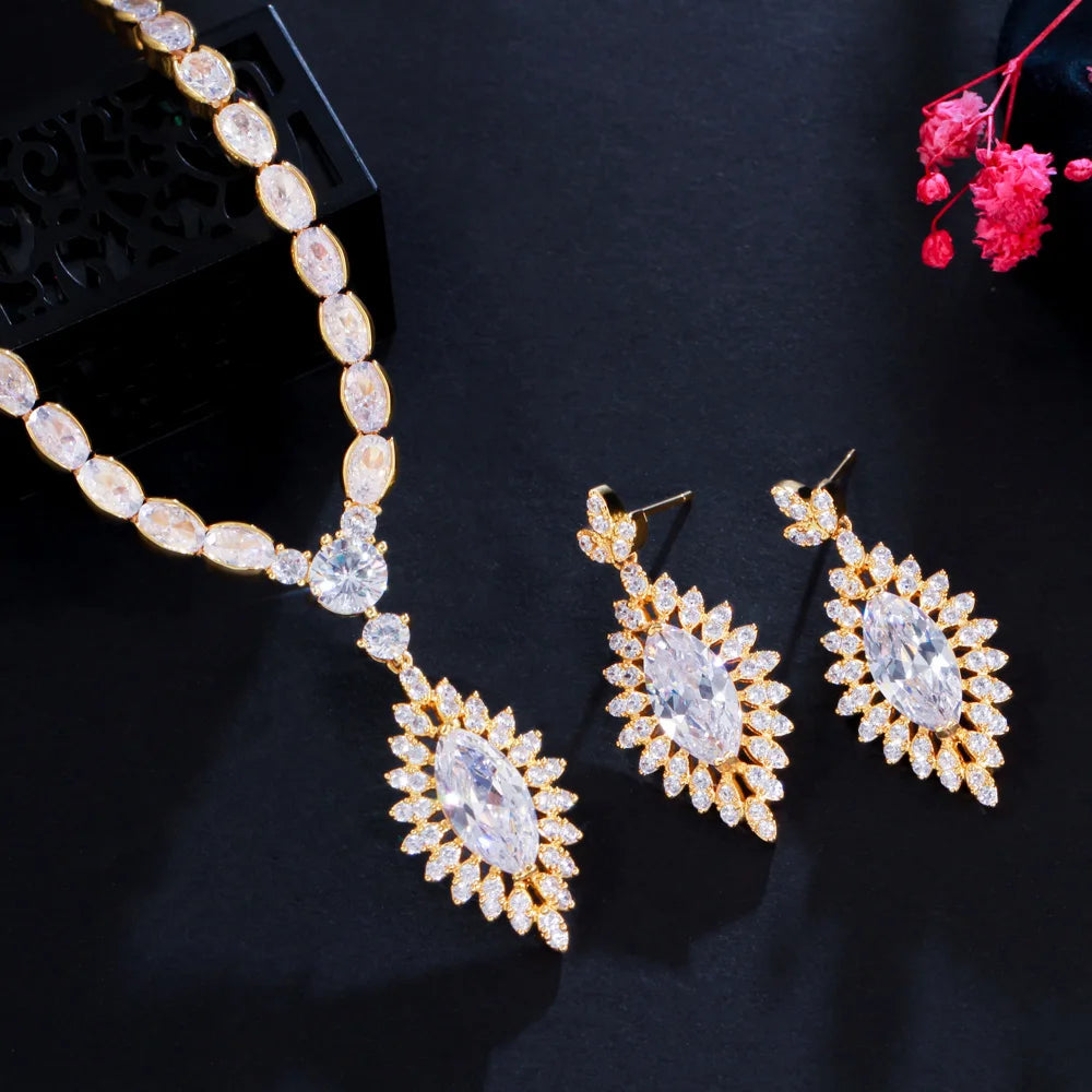 Gold tone cubic zirconia necklace with teardrop pendant and ornate leaf-drop earrings