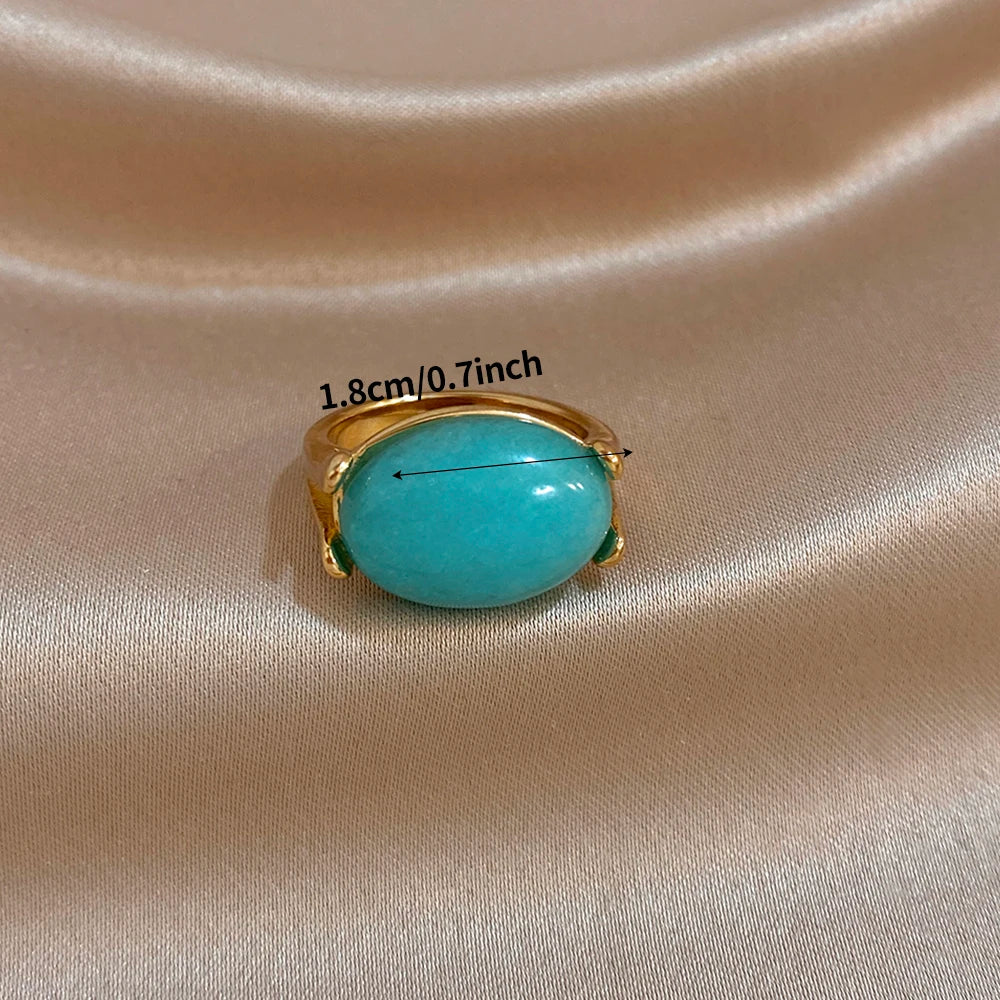 Gold-tone turquoise oval stone ring with curved band and prongs