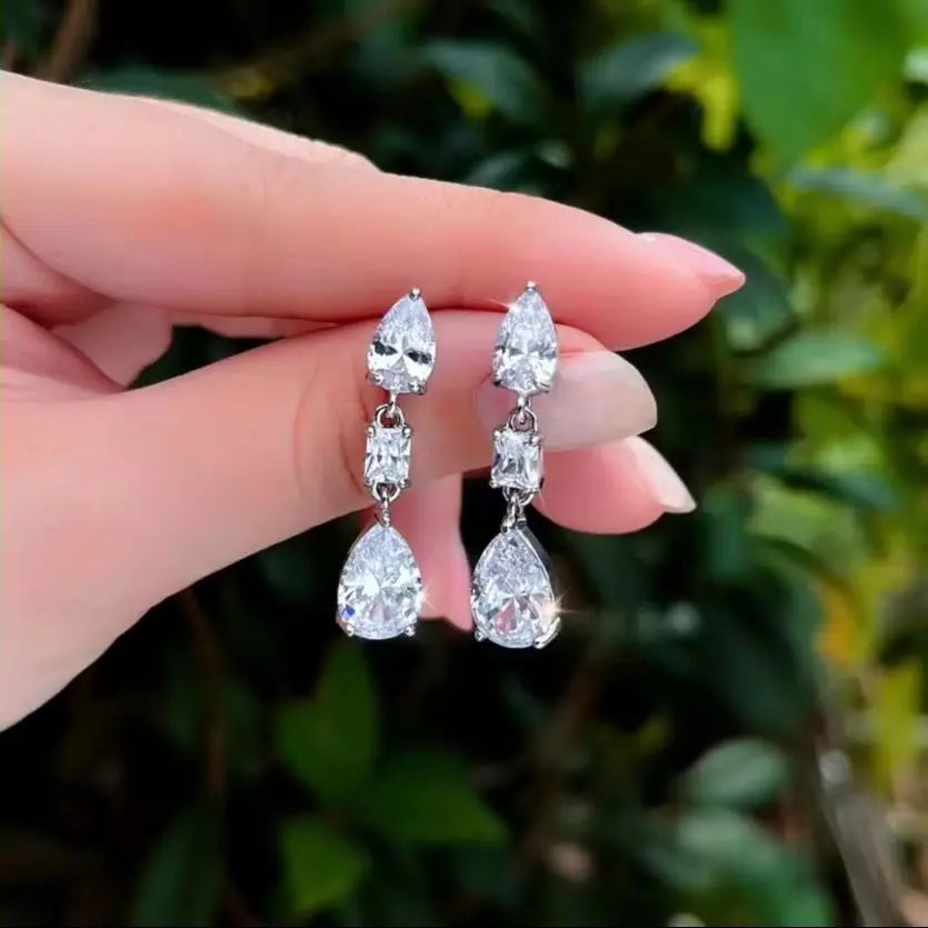 Pair of silver-plated crystal earrings with pear-shaped and rectangular stones.