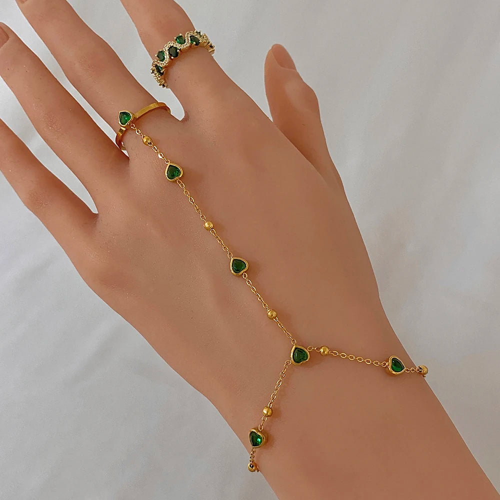 Gold-plated chain bracelet with green heart beads and matching ring on fingers