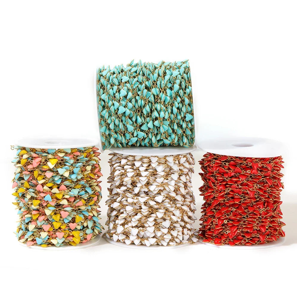Assorted enamel heart charm chains on spools: teal, white, and red with gold-tone links