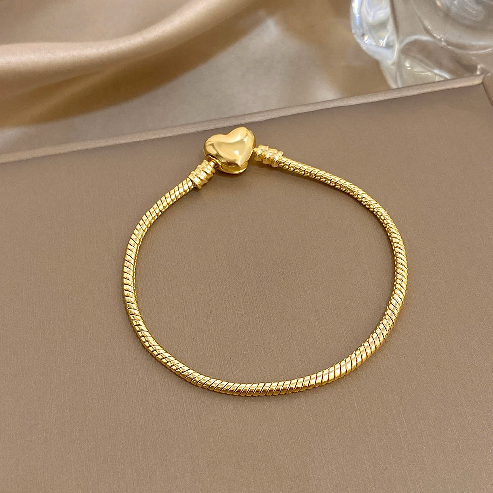 Gold-tone braided bracelet with heart-shaped clasp