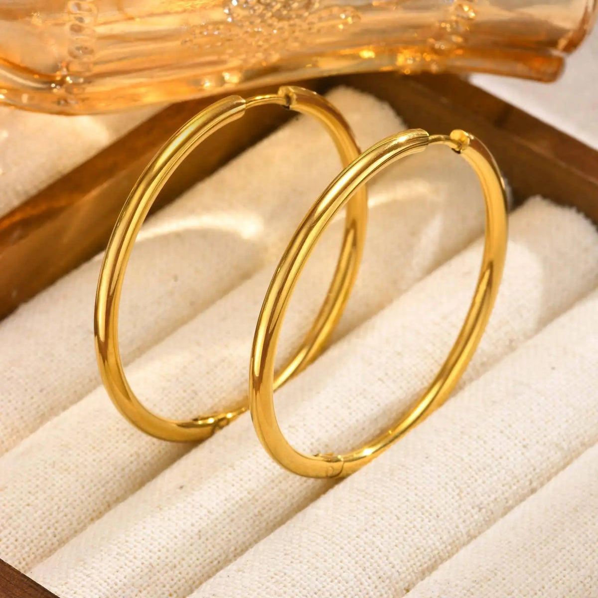 Pair of gold hoop earrings shown upright, with slim rounded bands.