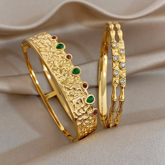 Gold-tone wide cuff bracelet set, embossed texture with green and red stones.