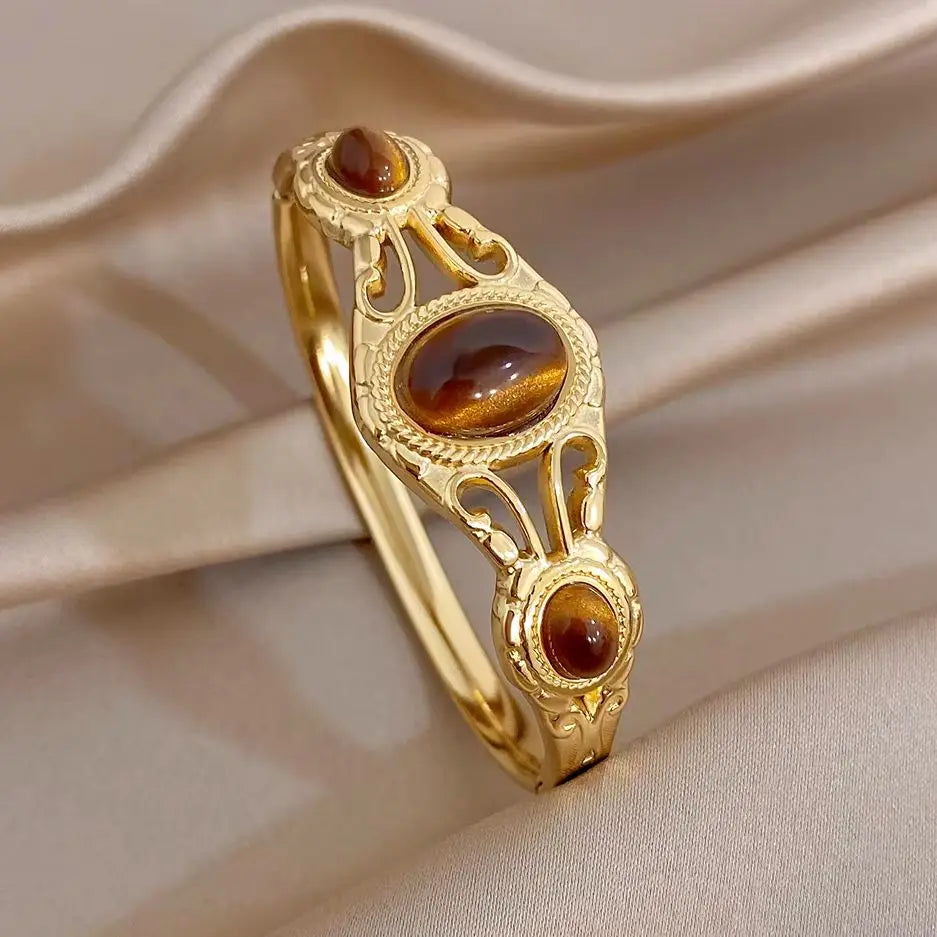 Gold-tone geometric cuff bangle with oval brown tiger-eye cabochon stones