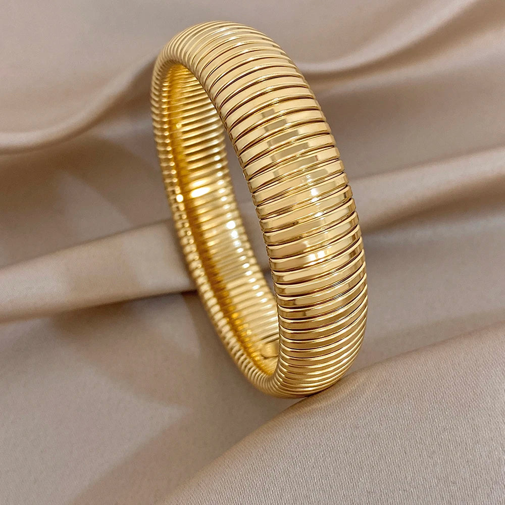 Gold-tone ribbed cuff bangles set, overlapping in a stacked duo