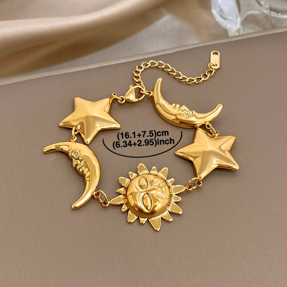 Gold-tone charm bracelet with star and crescent moon charms and a sun medallion centerpiece