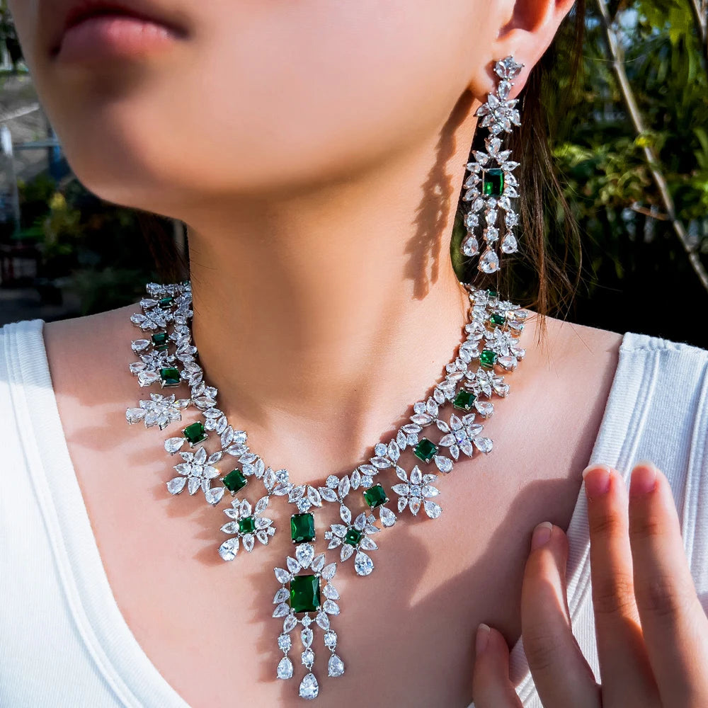 Emerald green cubic zirconia necklace and dangling floral earrings worn as a set