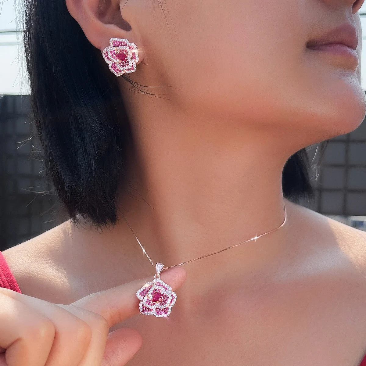 Close view of a rose-red flower CZ earring and matching pendant necklace
