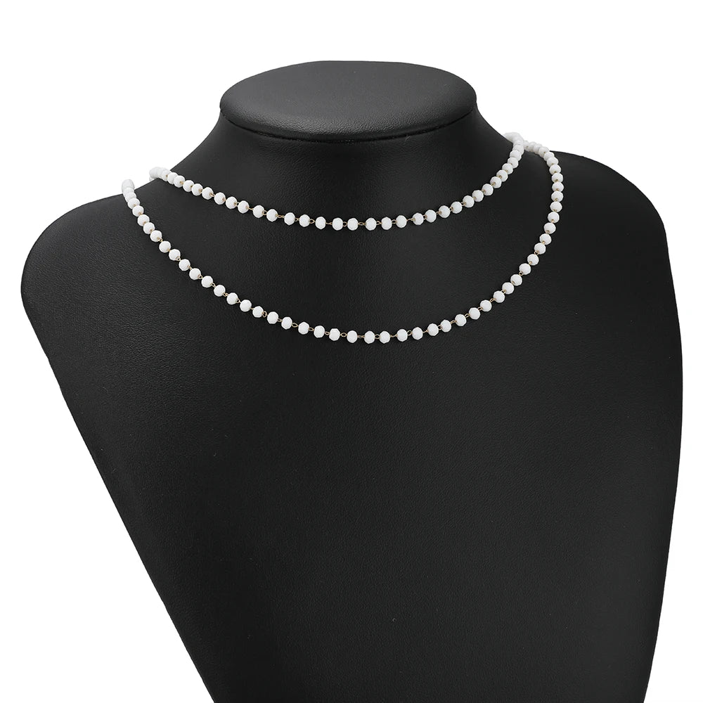 White pearl-like beaded necklace chain on black mannequin bust