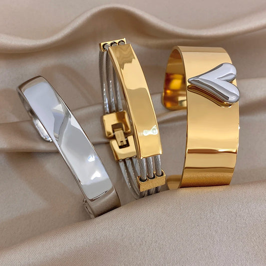 Gold and silver glossy chunky cuff bangles with geometric clasp details, stacked look