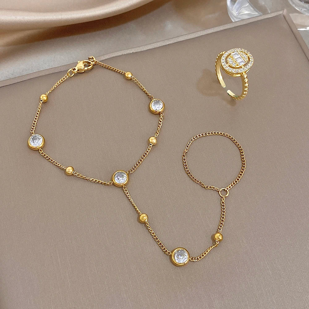 Gold-plated zircon bead chain bracelet and matching finger ring, laid out
