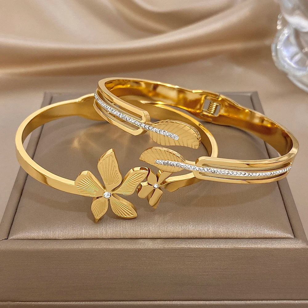 Gold-plated bangle set with two cuffs; floral and leaf motifs with clear zircon stones