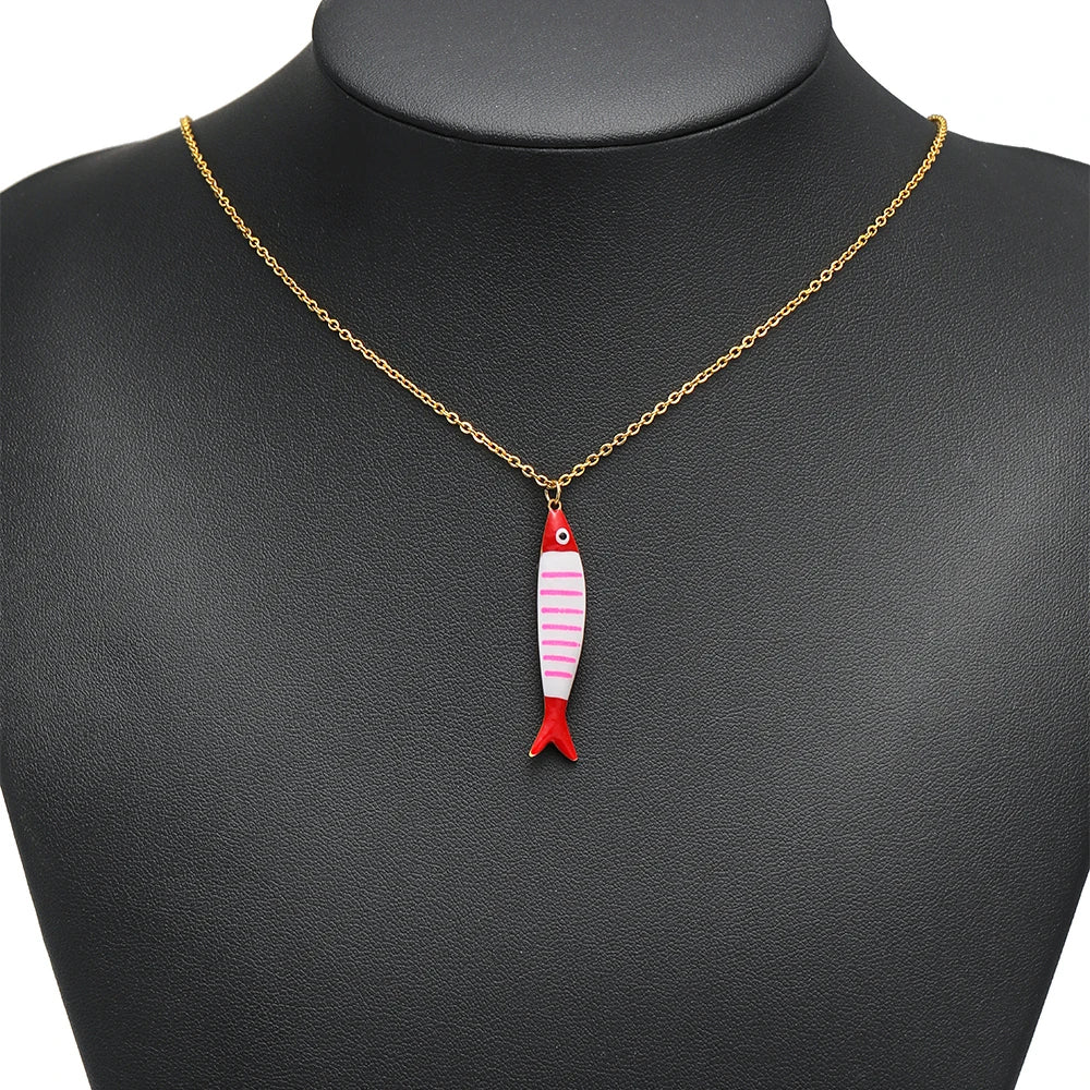 Fish enamel pendant charm with pink stripes, red fins, and gold loop on necklace