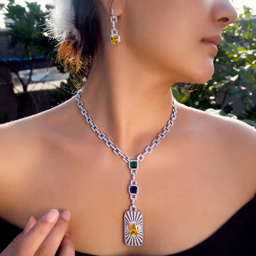 Zirconia cuban link necklace set on model with square green charm and dangling heart pendant