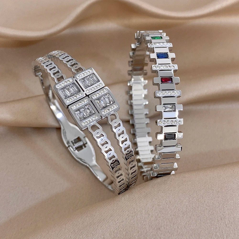 Two silver-toned zircon cuff bracelets with irregular geometric square stone accents