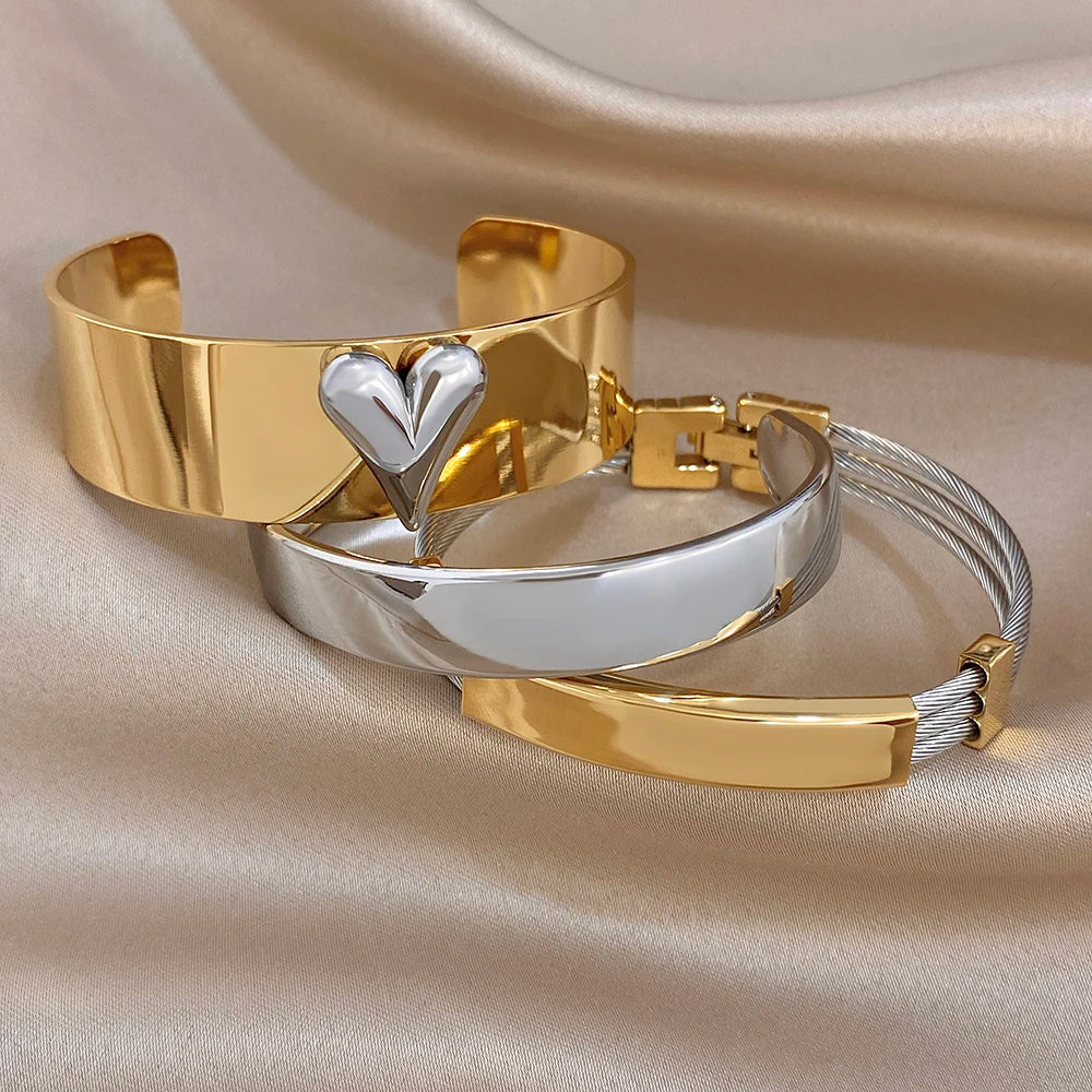Gold and silver cuff bangles with heart centerpiece and mixed chunky wide bands