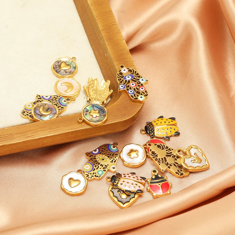 Assorted gold-tone beetle shell charm pendants with multicolor enamel and loop bails.