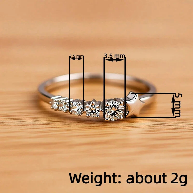 Silver-tone CZ ring on wood, side profile with star and round center stones
