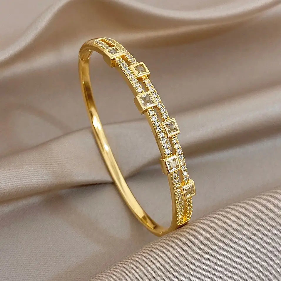 Gold-tone rhinestone bangle bracelet with square link accents, open cuff view