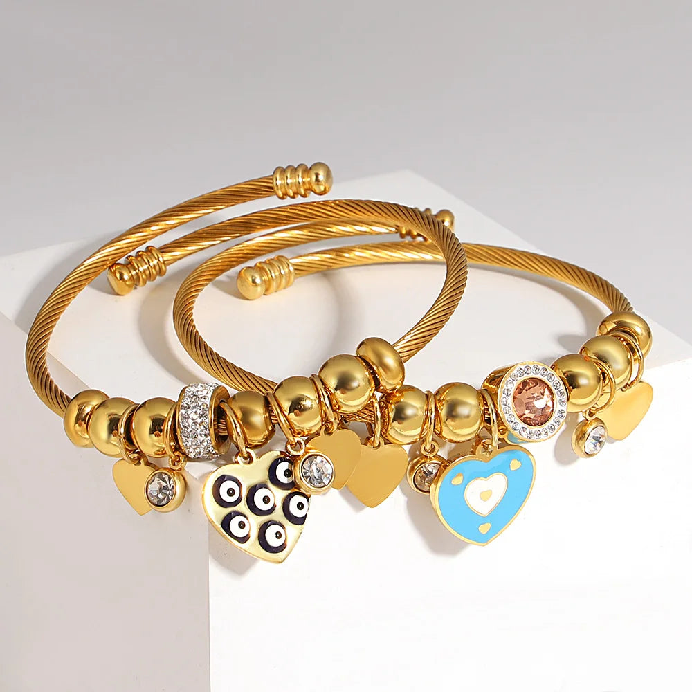Gold-tone braided charm bracelet with owl and blue heart enamel charms