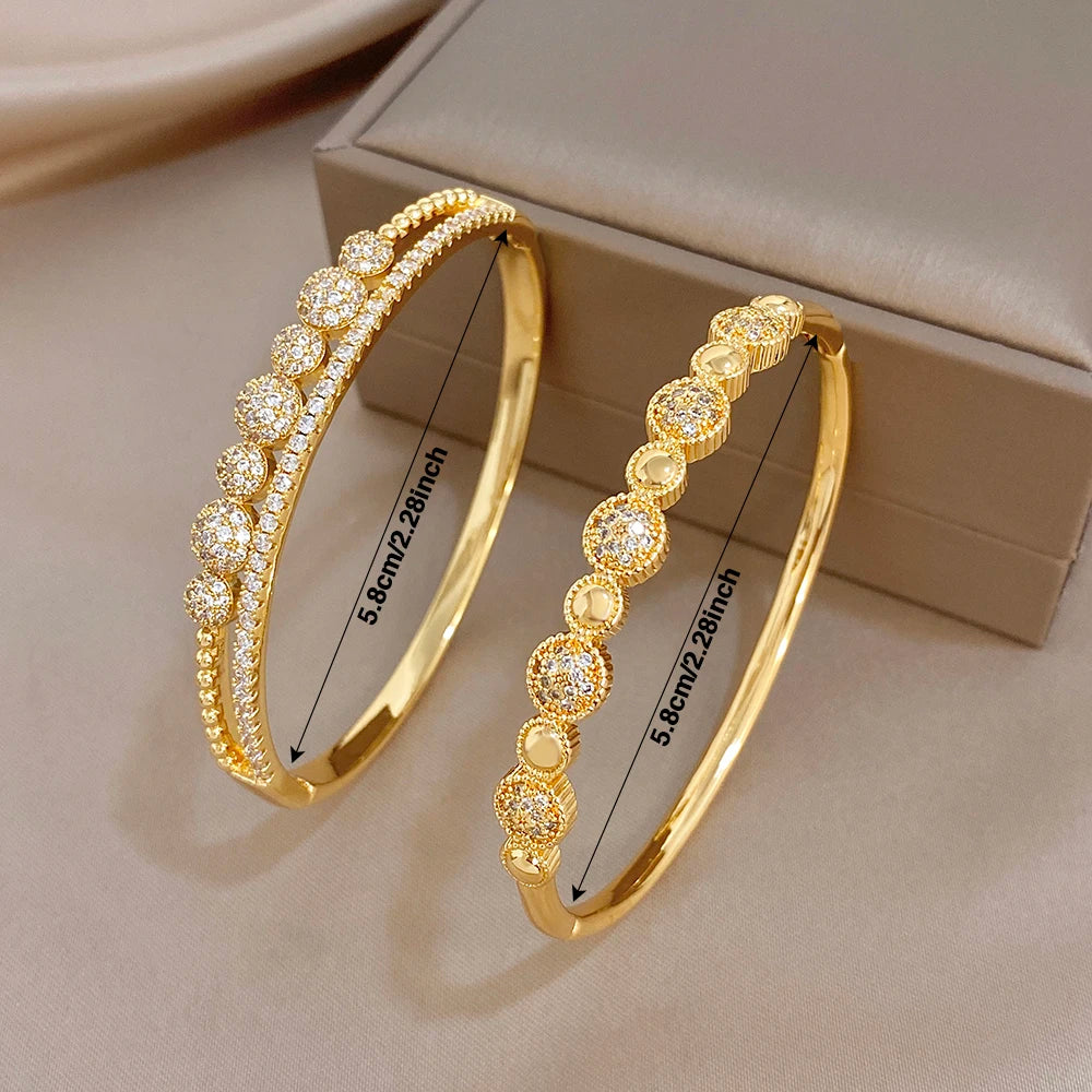 Pair of gold-tone cuff bangles with round zircon bead accents