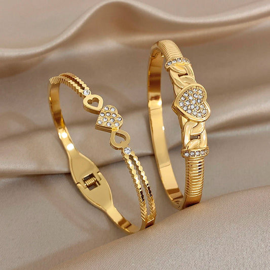 Gold-tone heart charm twisted knot cuff bangle bracelet with clear rhinestone details