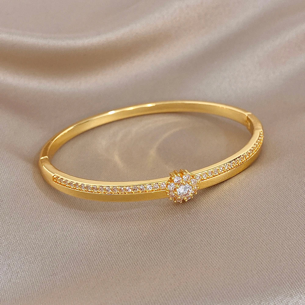 Gold-plated bangle with row of zircon stones and central zircon flower