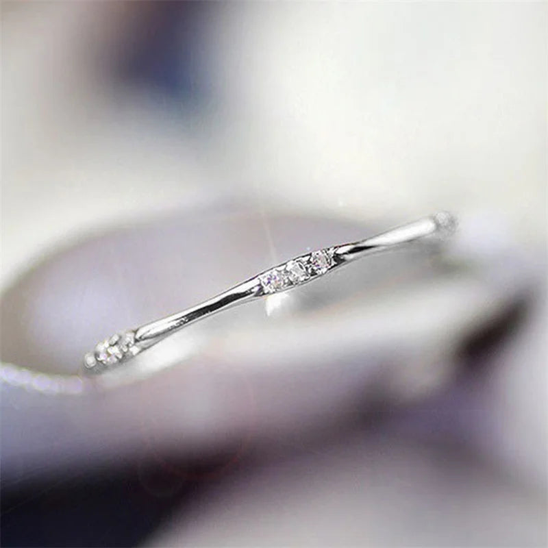 Minimalist cubic zirconia wedding ring, silver-tone side view with row of stones