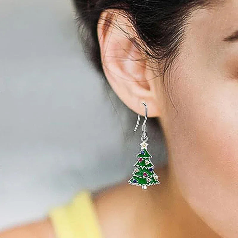 Christmas tree drop earring on a wearer's ear: green enamel tree with multicolor ornaments
