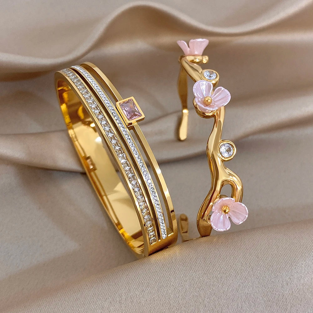 Gold-plated cuff bangle with pink flower branch charm and sparkling crystal band