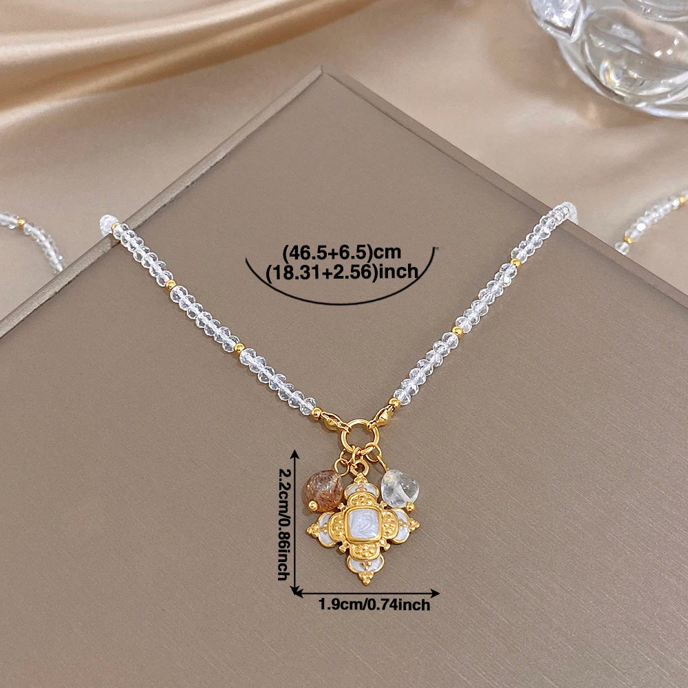 Gold-tone cross pendant necklace with clear crystal drops on a silver beaded chain