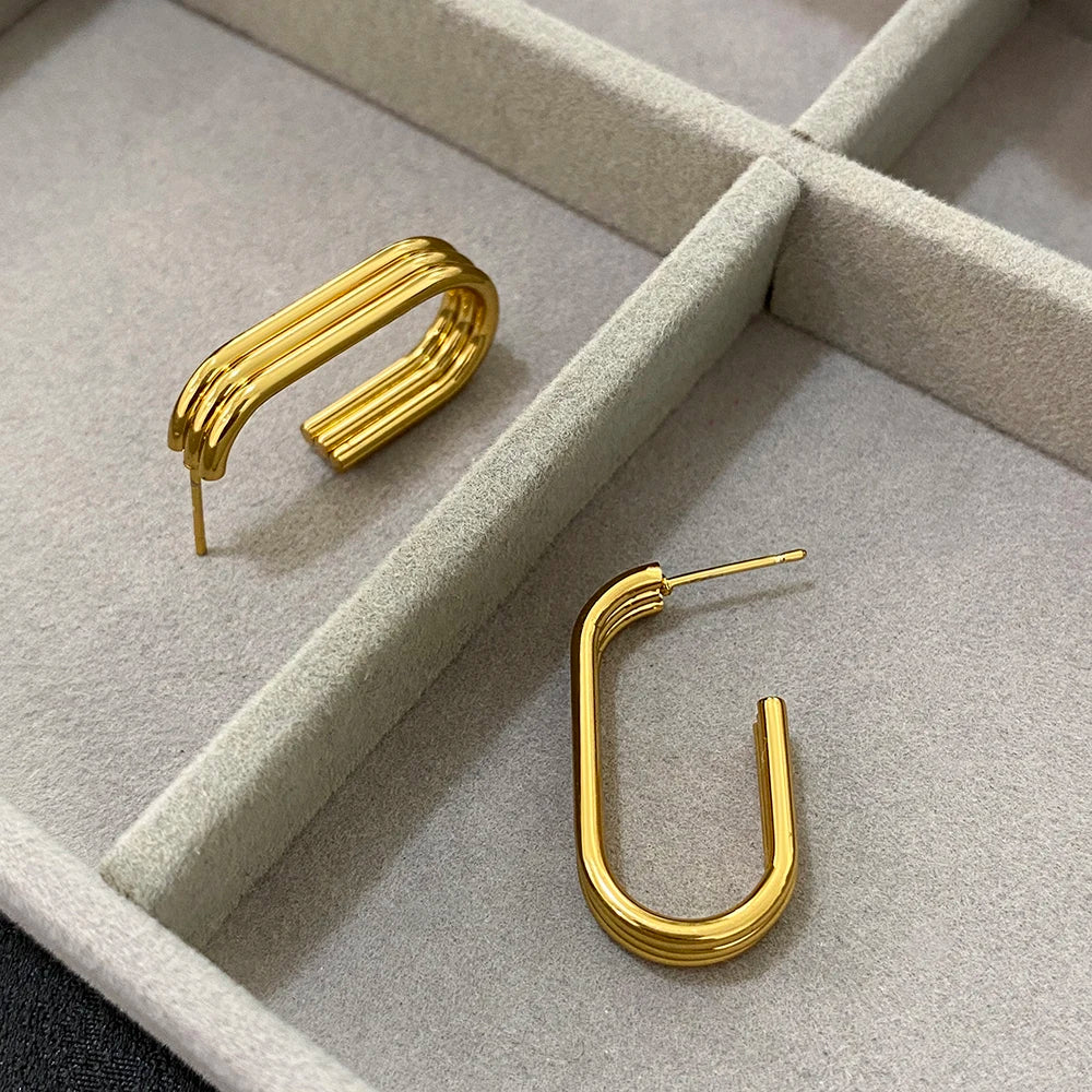 Gold-tone hoop earrings with open U-shaped frames and ridged bands