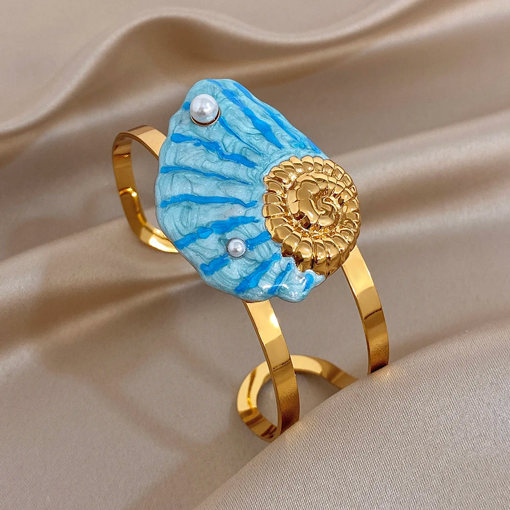 Gold-plated wide cuff bracelet with blue enamel seashell design and pearl
