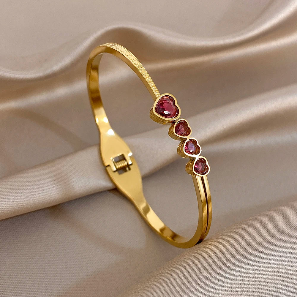 Gold tone bangle with purple heart zircon stones and hinged clasp detail
