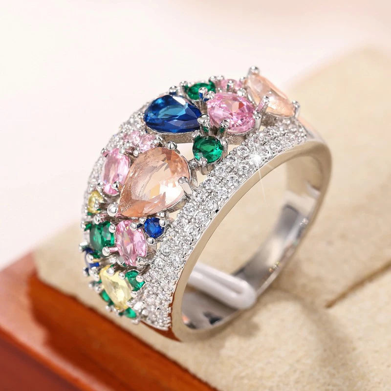 Silver-tone multicolor cubic zirconia band ring with oval and round stones, angled view.
