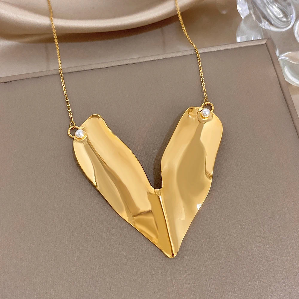 Gold-tone glossy heart pendant with small white pearl bead on each side