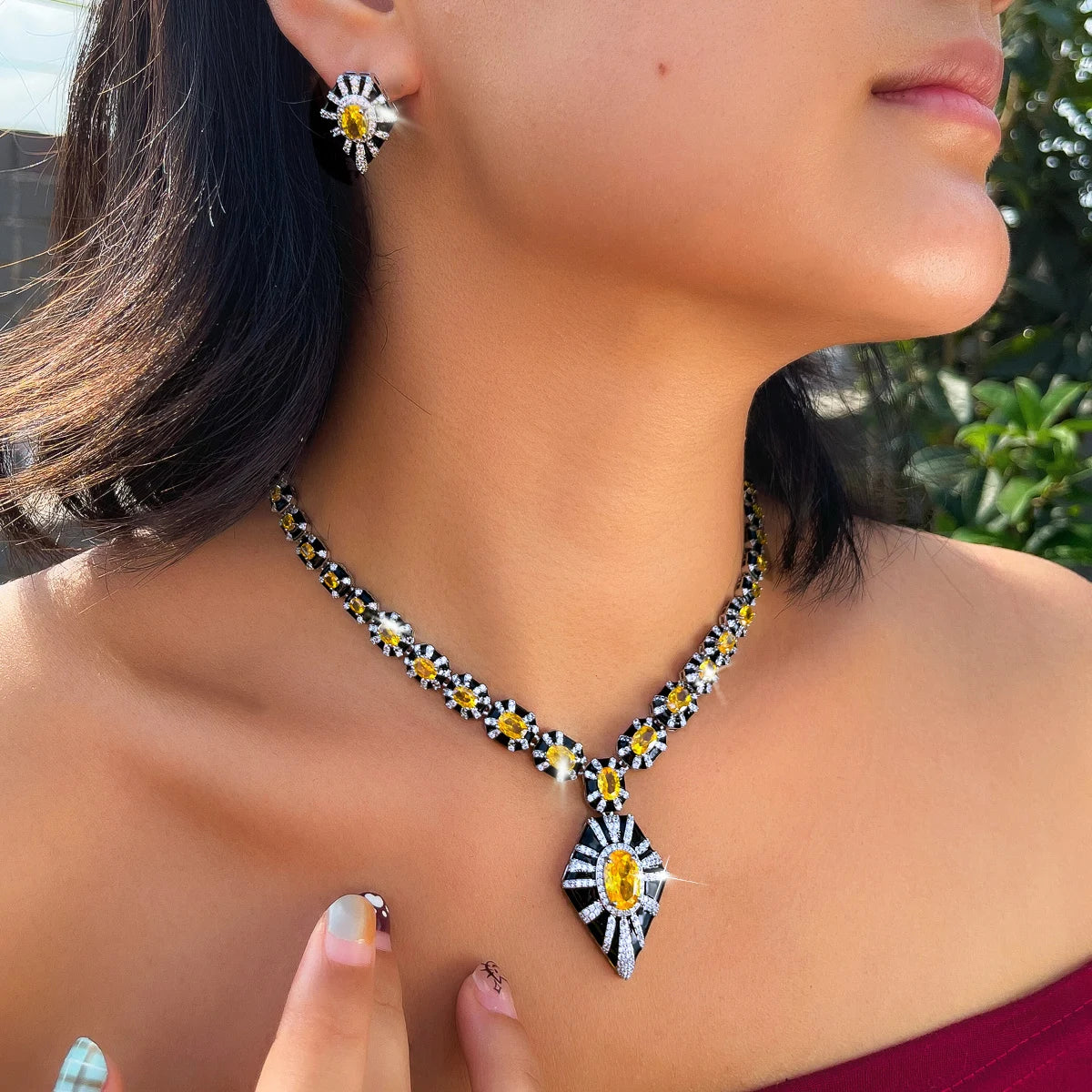 Black enamel necklace with yellow zircon pendant and matching earring, shown worn.