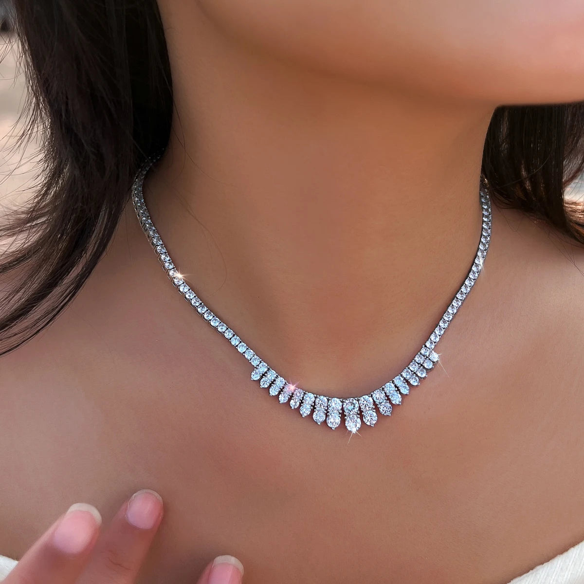 Cubic zirconia necklace shown close up, featuring a curved fringe of teardrop stones