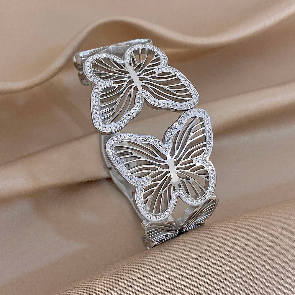 Silver-tone wide cuff bracelet with butterfly charms and rhinestone trim