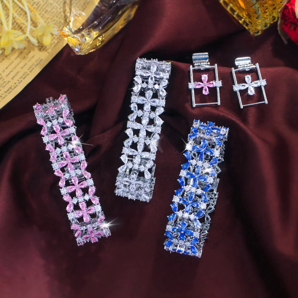 Three wide floral crystal tennis bracelets in pink, clear, and blue with matching clasp extensions