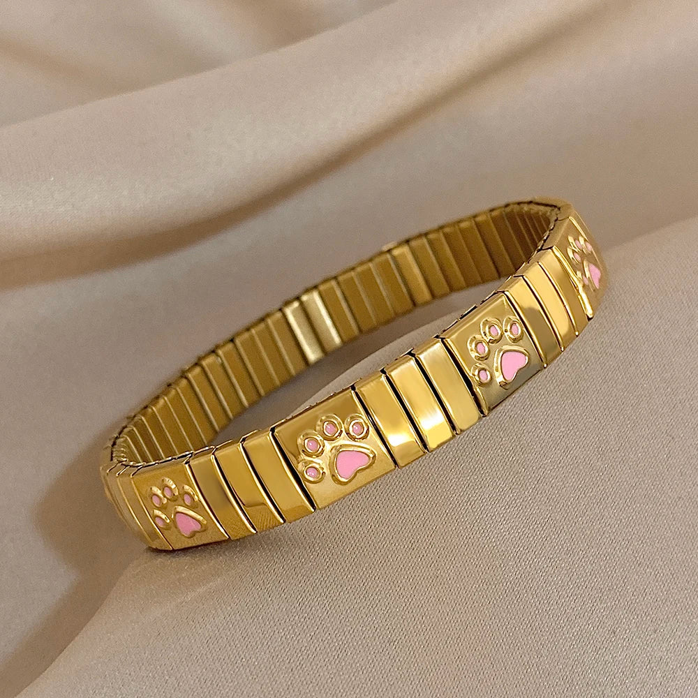 Gold enamel paw print link bracelet bangle with ribbed metal center, adjustable.
