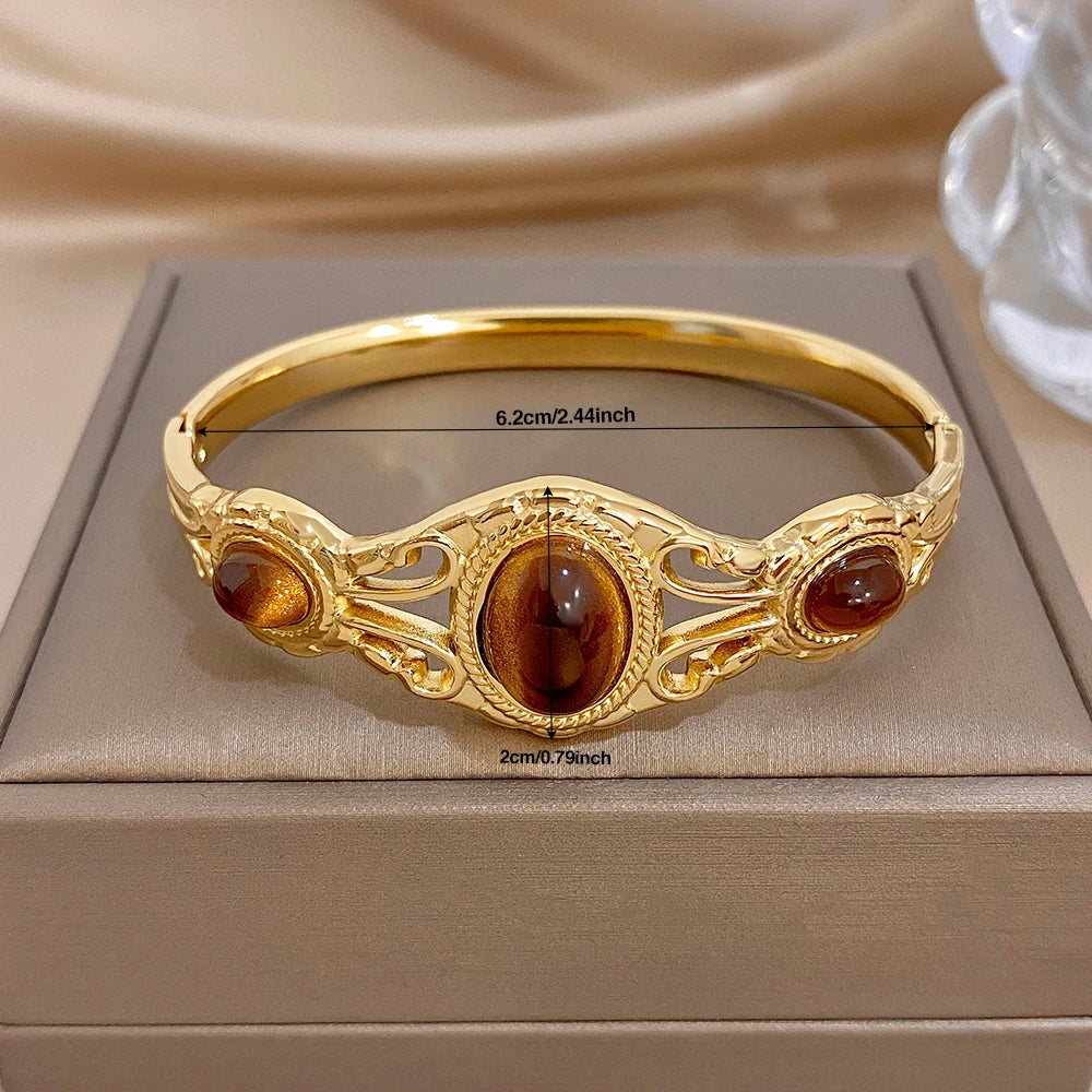 Gold-tone geometric cuff bracelet with three oval brown tiger-eye cabochons
