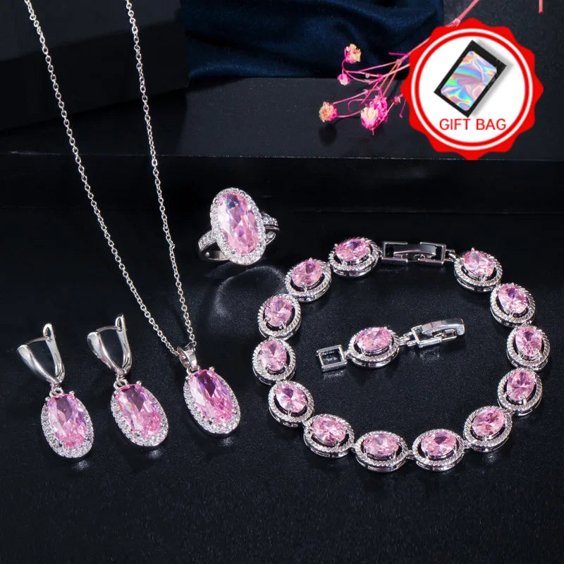 Oval pink CZ jewelry set with heart ring, dangling earrings, chain necklace, and bracelet