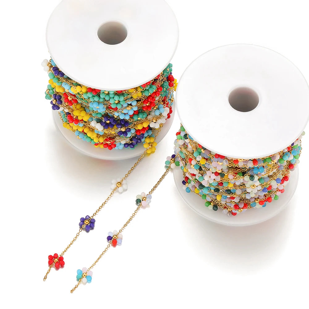 Colorful daisy flower beaded chains on two white spools with gold-tone links