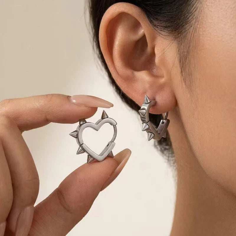 Silver heart hoop earrings with studded spikes around the heart center