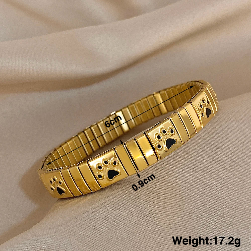 Gold enamel paw print link bracelet bangle with square bezel details, adjustable wristband.